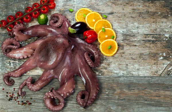 Isolated octopus with wrapped tentacles, arranged with fresh vegetables and free advertising space.