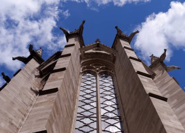 Notre Dame, Paris, Fransa. Katedralin güneşli bir günde heykelcikli bir bölümünün görüntüsü, mavi gökyüzü ve beyaz bulutlar..