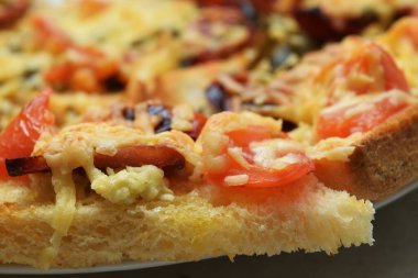 Tomato and sausage slices on baked toast with cheese
