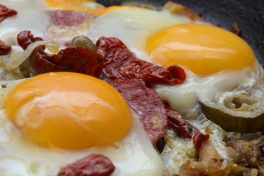 Yağda yumurta, kurutulmuş domates, soğan ve turşu.