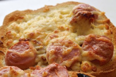 Peynirli, sosisli ve güneşte kurutulmuş domatesli kızarmış ekmek.