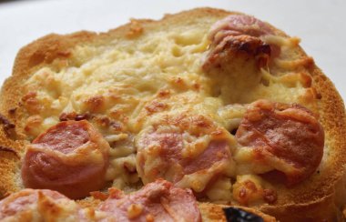 Peynirli, sosisli ve güneşte kurutulmuş domatesli kızarmış ekmek.