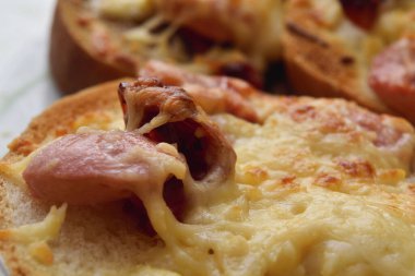 Peynirli, sosisli ve güneşte kurutulmuş domatesli kızarmış ekmek.