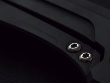 Katlanan bıçağın kutsanmış duralüminyum çerçeve kilidinde iki vida ve yarım daire şeklinde bir kafa.