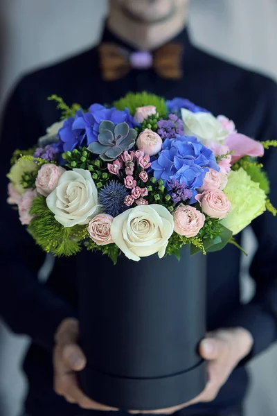 Hombre elegante entrega flores en la caja —  Fotos de Stock