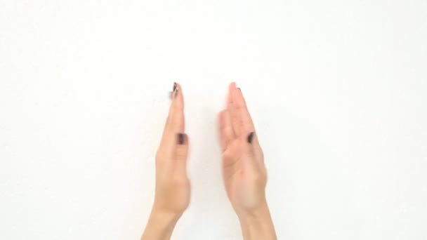 一个有黑色指甲的年轻女人的美丽的手在运动中显示出修指甲的效果 拍拍他们的手 手指触摸指甲 手摸另一只手 白色背景 — 图库视频影像