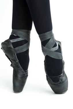 Beyaz arka planda, eski, yıpranmış siyah Pointe ayakkabılarıyla kadın balerin bacakları. Klasik Bale için Geleneksel Terlikler.