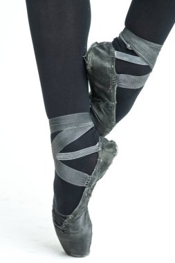 Beyaz arka planda, eski, yıpranmış siyah Pointe ayakkabılarıyla kadın balerin bacakları. Klasik Bale için Geleneksel Terlikler.