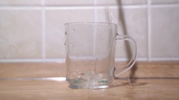 Tegen Achtergrond Van Een Houten Tafel Een Transparant Glas Wordt — Stockvideo