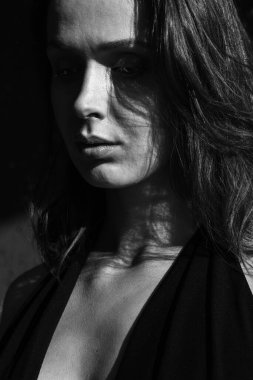 Genç esmer bir kızın portresi. Ciddi ya da saplantılı bir ifadeyle başka yere bakıyor. Siyah beyaz fotoğraf