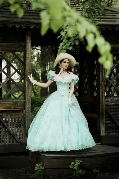 Młoda Piękna Dziewczyna Niebieskiej Sukience Kręconymi Włosami Kapeluszu Stoi Drewnianej — Zdjęcie stockowe