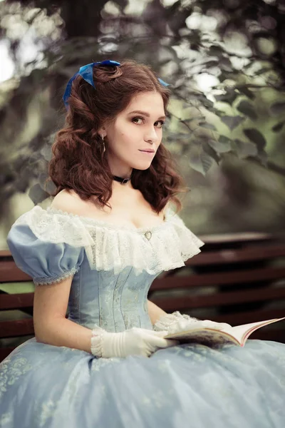 Mladá Krásná Dívka Modrých Šatech Kudrnatými Vlasy Sedí Lavičce Drží — Stock fotografie