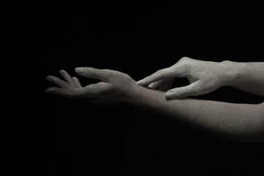 Yaşayan bir kadın heykelinin elleri, bir el diğerinin üzerinde dinleniyor.