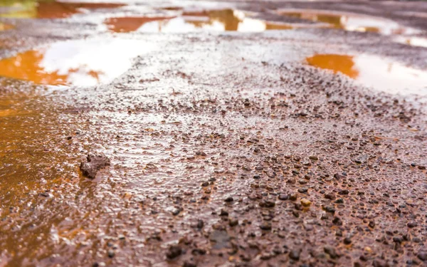 De rode modder weg heeft vele putten, slappe wegen — Stockfoto
