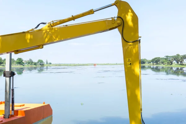 La excavadora está cavando el borde del agua de nuevo . — Foto de Stock