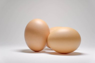 Beyaz arka planda üç tavuk yumurtası..