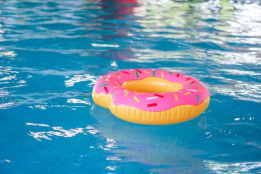 Bir havadar dalga yansıması ile mavi su üzerinde yüzen yüzük yüzmek