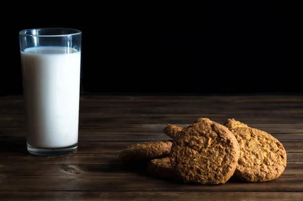 Pila di biscotti di avena e vetro di latte su superficie di legno — Foto Stock