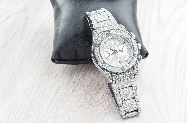 Moderní hodinky s lesklými pastami a drahokamy na dřevěném pozadí — Stock fotografie