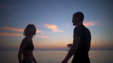 Siluetleri sportif insan highfive deniz arka plan vermek. Ağır çekim.