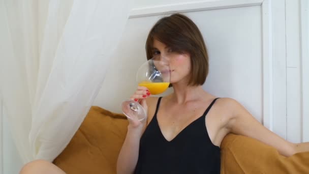 Gorgeous kvinna dricker apelsinjuice i lyx sovrummet slow motion — Stockvideo