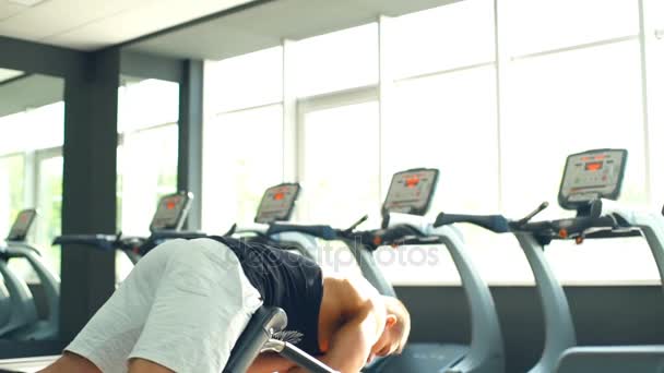 Bakifrån manliga kroppsbyggare gör översträckning i gymmet — Stockvideo