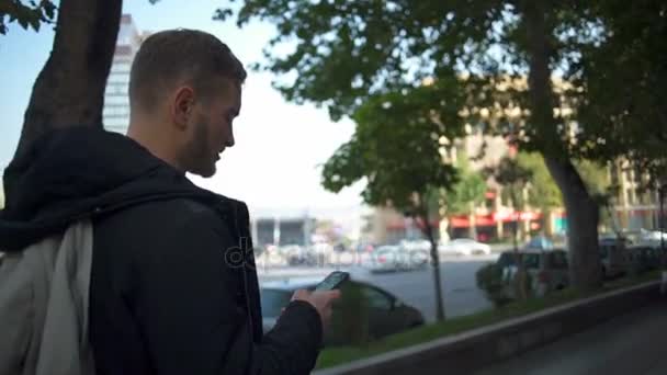 Yakışıklı delikanlı sokak ağır çekimde onun smartphone kullanarak — Stok video