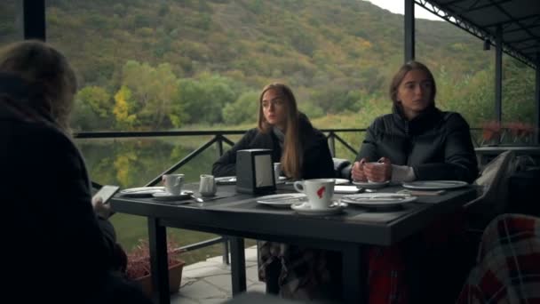 Un grupo de mujeres sentadas en la terraza en un restaurante esperando sus comidas — Vídeos de Stock