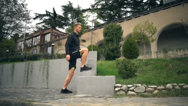Un jeune bel homme qui fait un exercice intensif à l'extérieur — Video