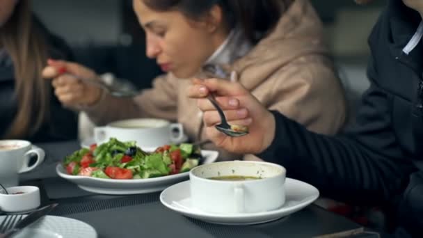 Jonge vrolijke vrienden eten in een restaurant op een terras in de buurt van de vijver-closeup — Stockvideo