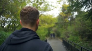 Bir genç sağlıklı adam park closeup ağır çekimde koşu yerleştirmek