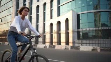 güzel genç kadın şafakta şehir merkezinde bir bisiklet sürmek