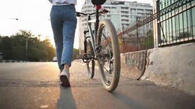 Şafakta yanında Bisiklet caddeden aşağı yürüyüş kadın bacakları yukarı kapatın