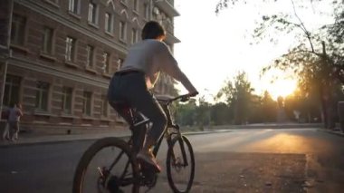 Arkadan Görünüm genç erkek sabah şehirde bisiklet sürmek