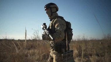 Airsoft asker bir tüfek ve tam Nato mühimmatı alanına yürüyor