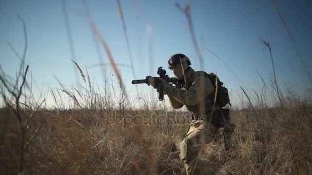 Airsoft στρατιώτης με ένα τουφέκι και πλήρη πυρομαχικά ΝΑΤΟ στοχεύοντας στο πεδίο — Αρχείο Βίντεο