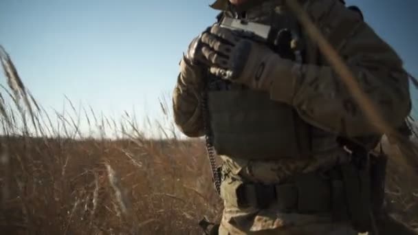 Soldado Airsoft en plena munición de la OTAN con una glock caminando en el campo — Vídeos de Stock