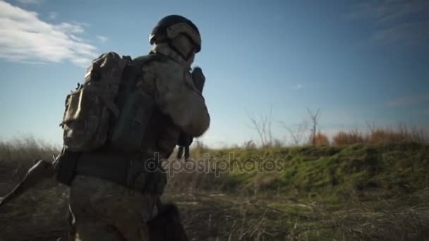 Солдат Airsoft с винтовкой и полным боеприпасами НАТО бежит и целится — стоковое видео