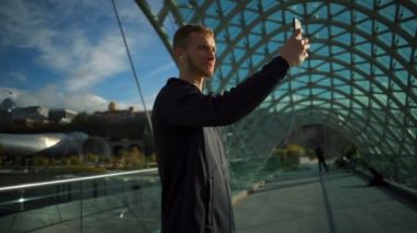 Yakışıklı delikanlı kulaklıklarla köprü ağır çekim video aramasý yapma