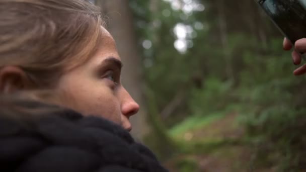 Junge schöne Frau macht ein Foto und lächelt glücklich in einer Waldzeitlupe — Stockvideo