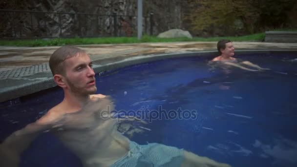 A young handsome man relaxing in the hot sulfur spring slow motion — Stock Video