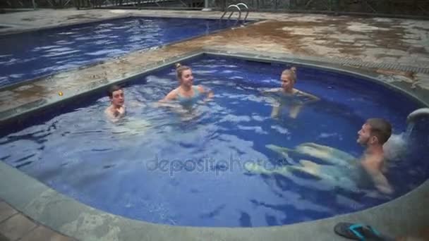 Fröhliche junge Freunde schwimmen in der heißen Schwefelquelle Zeitlupe — Stockvideo