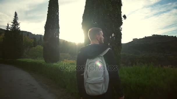 Pareja joven con mochilas caminando en un hermoso parque admirándolo en cámara lenta — Vídeo de stock