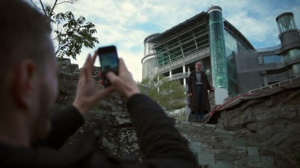 Mladý muž pořizování fotografii dívky před zpomalené krásný vodopád — Stock video