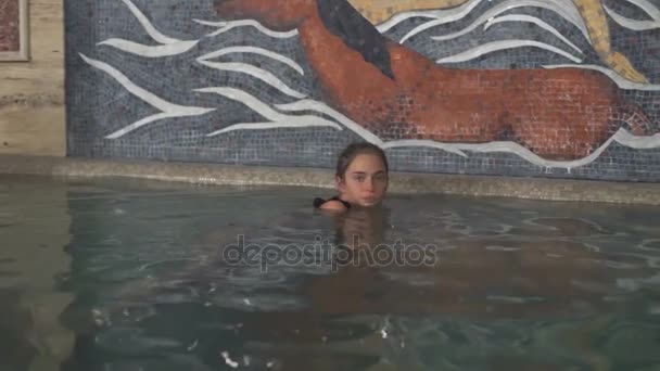 Una joven encantadora nadando en la piscina en cámara lenta — Vídeos de Stock