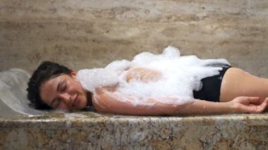 Bir çekici esmer gülümseyen, rahatlatıcı ve Türk banyo keyfi