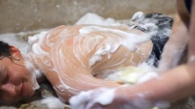 Neşeli bir esmer gülümseyen, rahatlatıcı ve Türk Hamamı closeup zevk