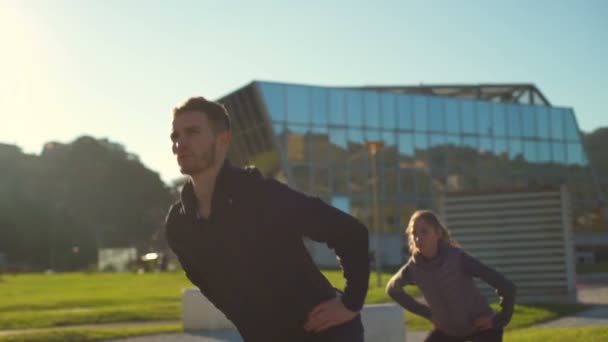 Een groep jonge vrienden met gezonde levensstijl buiten de kant lunges doen — Stockvideo