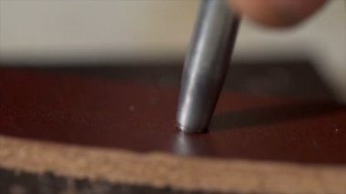 Bir deri şerit atölye delikleri yapma eller closeup görünümünü mans