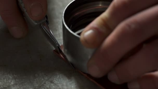 Vista de cerca de las manos de los artesanos cortando los ángulos de cuero en la mesa — Vídeos de Stock